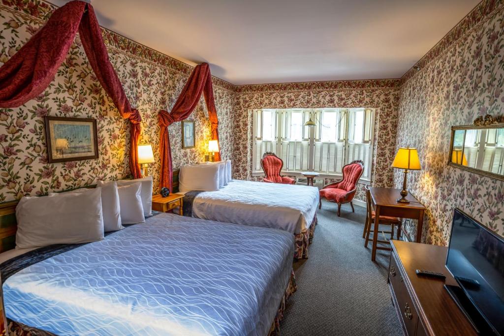 ein Hotelzimmer mit 2 Betten und einem TV in der Unterkunft Murray Hotel in Mackinac Island