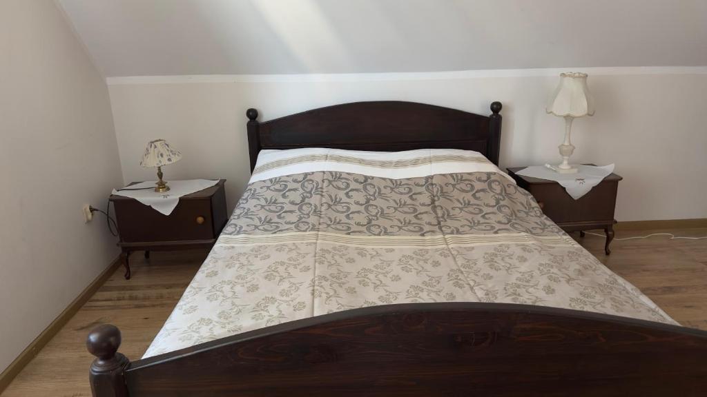 a bedroom with a wooden bed with two night stands at Dom w sercu Kaszub in Parchowo