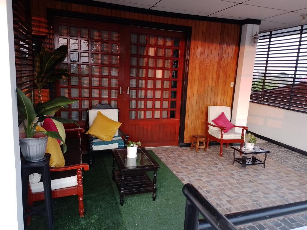 HABITACIÓN AMUEBLADA Y ACOGEDORA في Puerto Callao: غرفة بها كراسي وطاولات وباب