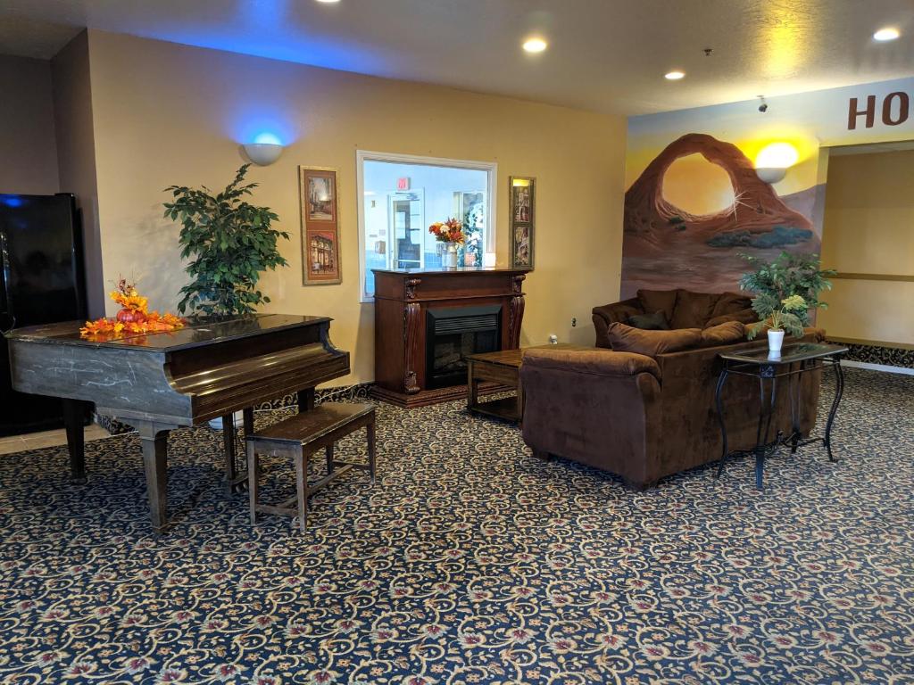 a living room with a piano and a couch at Horizon Hotel in Vernal