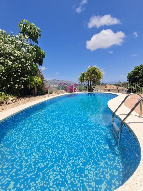 uma grande piscina com água azul em Casa Nirvana em Benidoleig