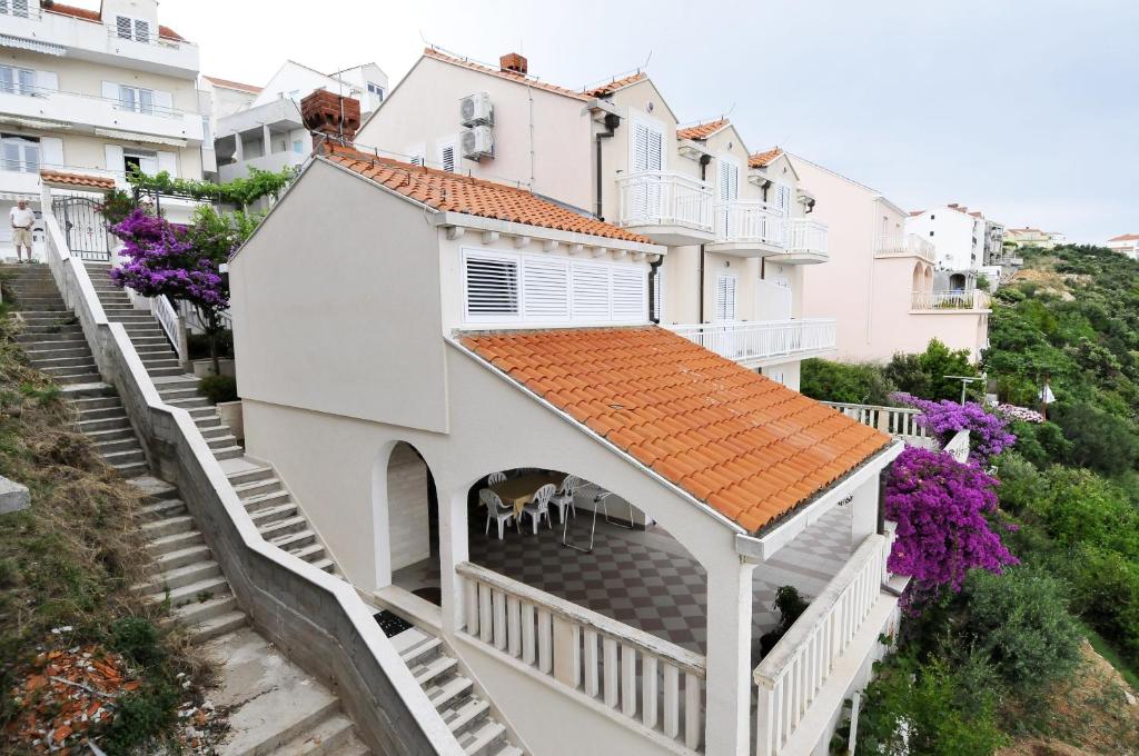 a white house with stairs and purple flowers at Apartments Bugenvila in Cavtat