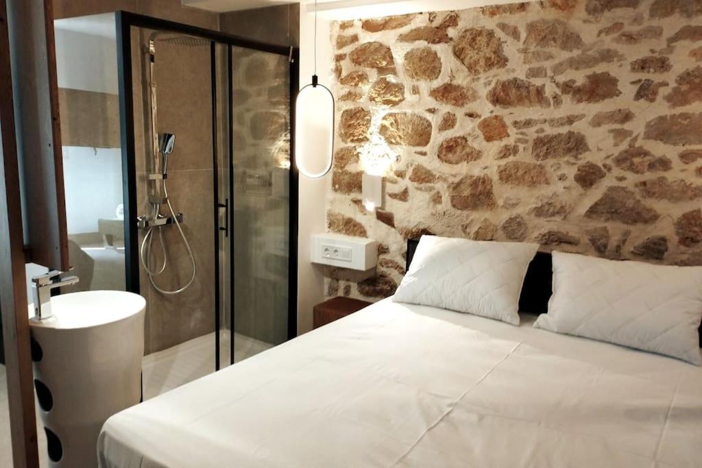 a bedroom with a bed and a bathroom with a shower at Χώρος με επιλεκτική λιτότητα και χαμάμ in Athens