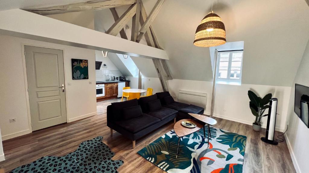 - un salon avec un canapé et une table dans l'établissement RhizHome - Coeur de ville, appartement spacieux, à Auxerre