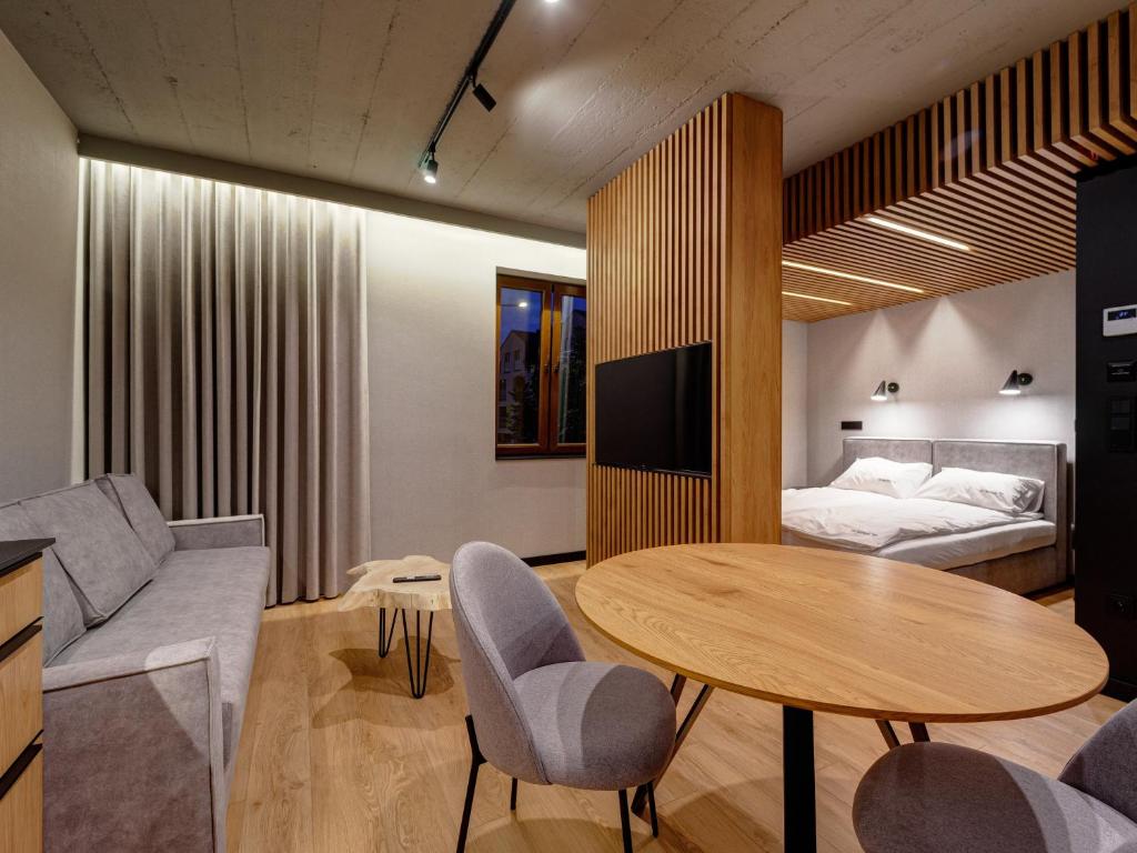 uma sala de estar com uma mesa e uma cama em Stek Apartments em Skawina