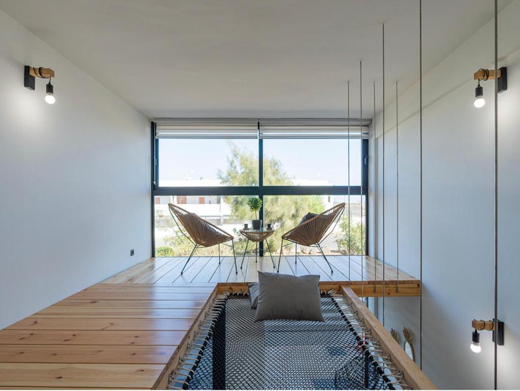 Habitación con mesa, sillas y ventana grande. en Las Gemelas del Mar, en Cotillo