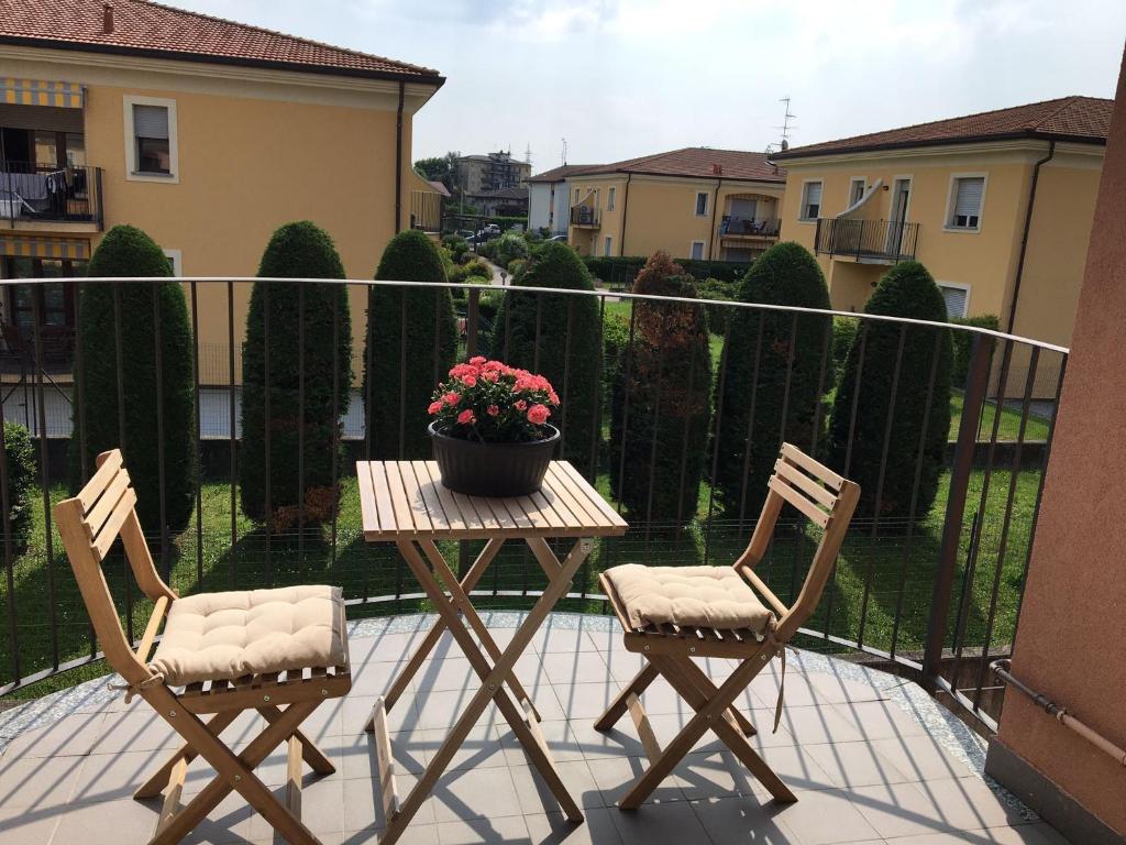 Castiglione OlonaにあるAppartamento BELVEDEREのバルコニー(椅子2脚、鉢植えの植物付きテーブル付)
