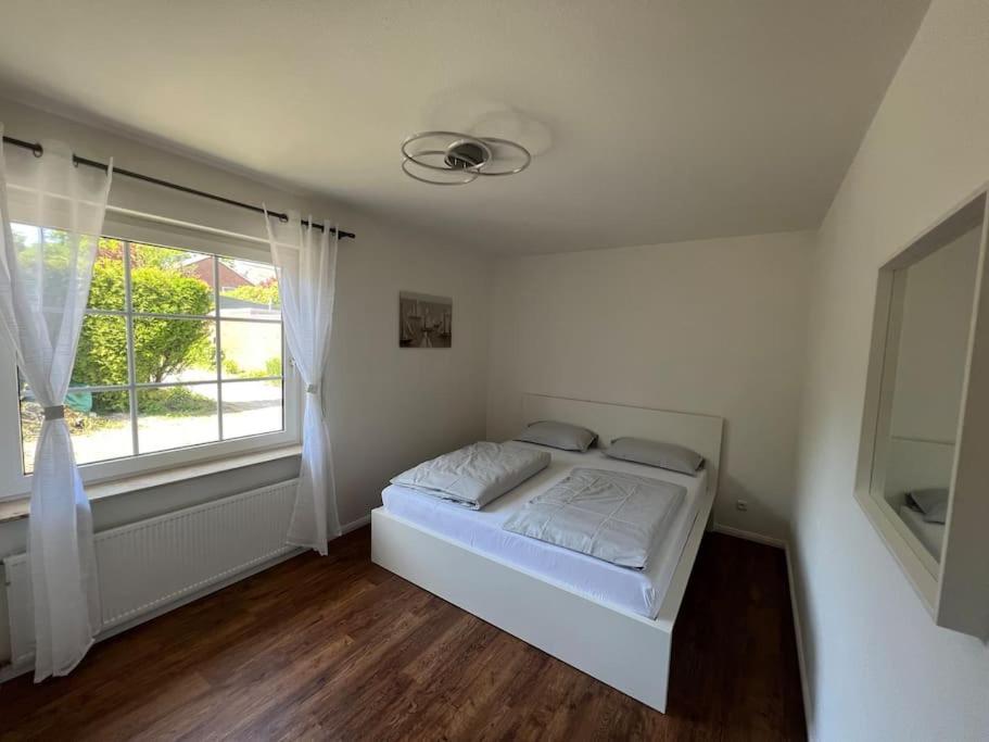 een witte slaapkamer met een bed en een raam bij Ganze Haus für sich 6 Schlafplätze in Buxtehude