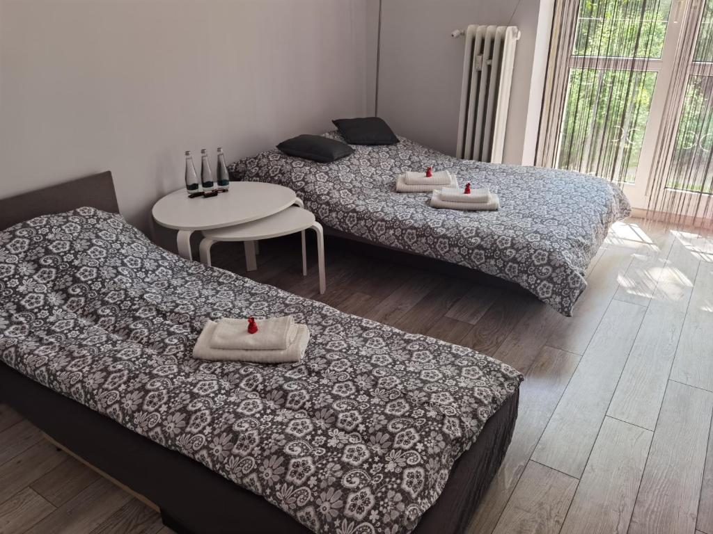 Una habitación con 2 camas y una mesa con toallas. en Apartament Tuwima, en Zabrze