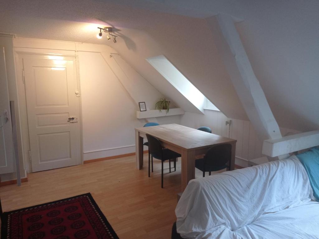 Gemütliche Dachwohnung في سانت غالن: غرفة مع طاولة وكراسي وسرير