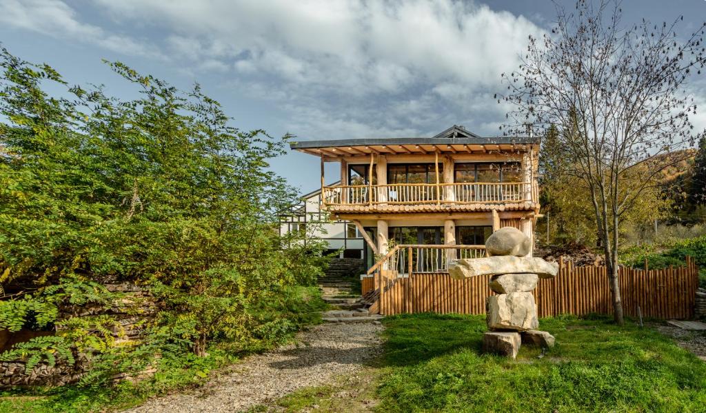 uma casa de madeira com uma varanda e uma casa em OM Resort em Gura Teghii