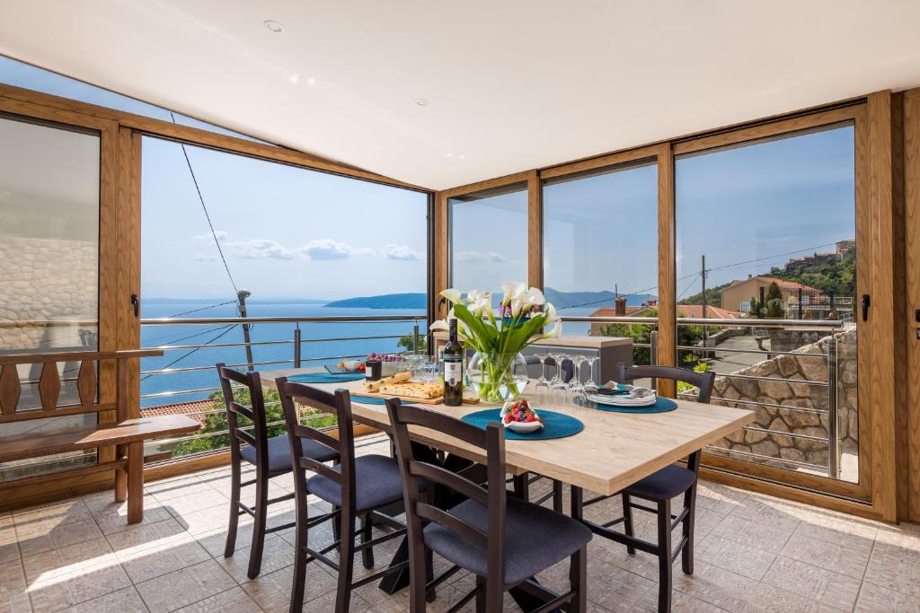 uma sala de jantar com uma mesa e vistas para o oceano em APARTMAN UHAČ em Mošćenička Draga