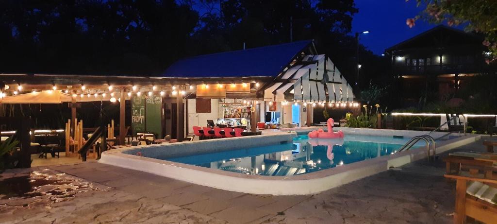 a swimming pool in front of a house at night at Guava Grove Resort & Villas in Sandy Bay