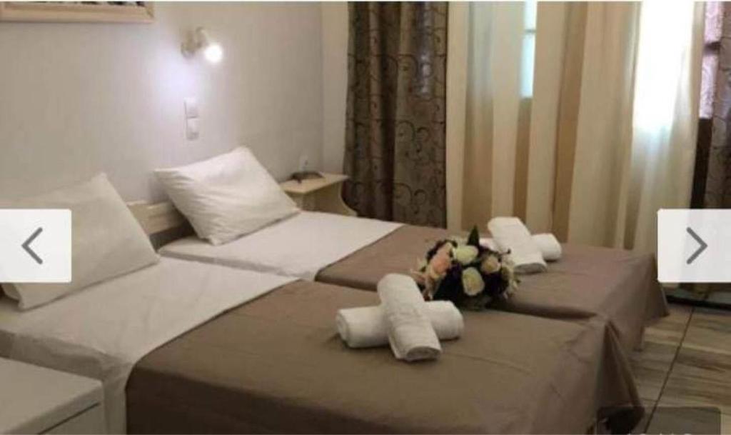 a bedroom with two beds with stuffed animals on them at Dimitris Studios in Perissa