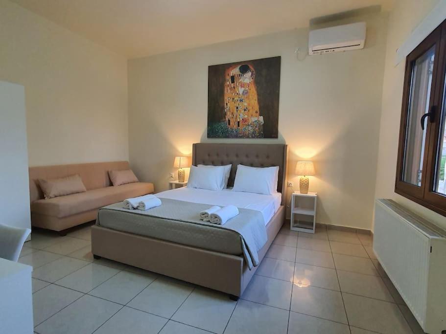 a bedroom with a large bed and a couch at Livas City Relaxing Apartment in Kos