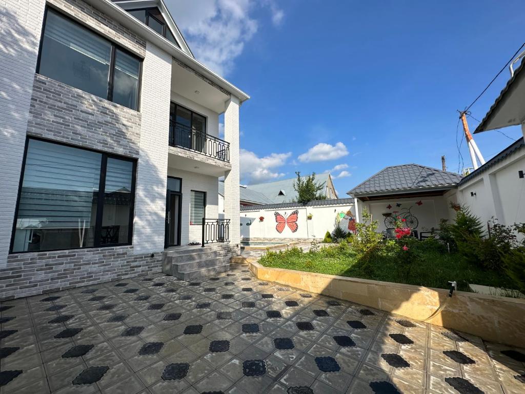 a house with a stone walkway in front of it at Qafqaz Suite Bluesky in Gabala