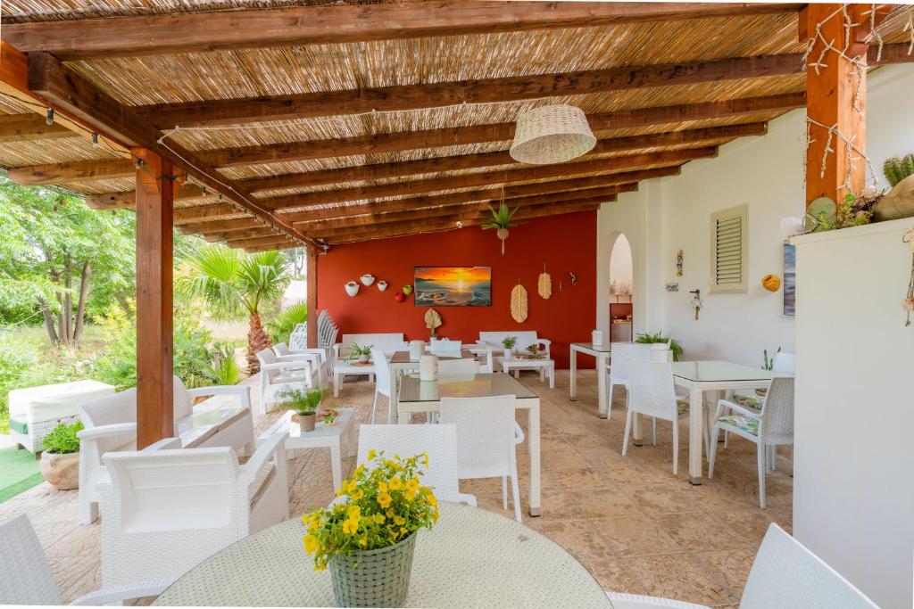 un restaurante con mesas blancas y sillas blancas en Villa Elisa, en Torre Lapillo