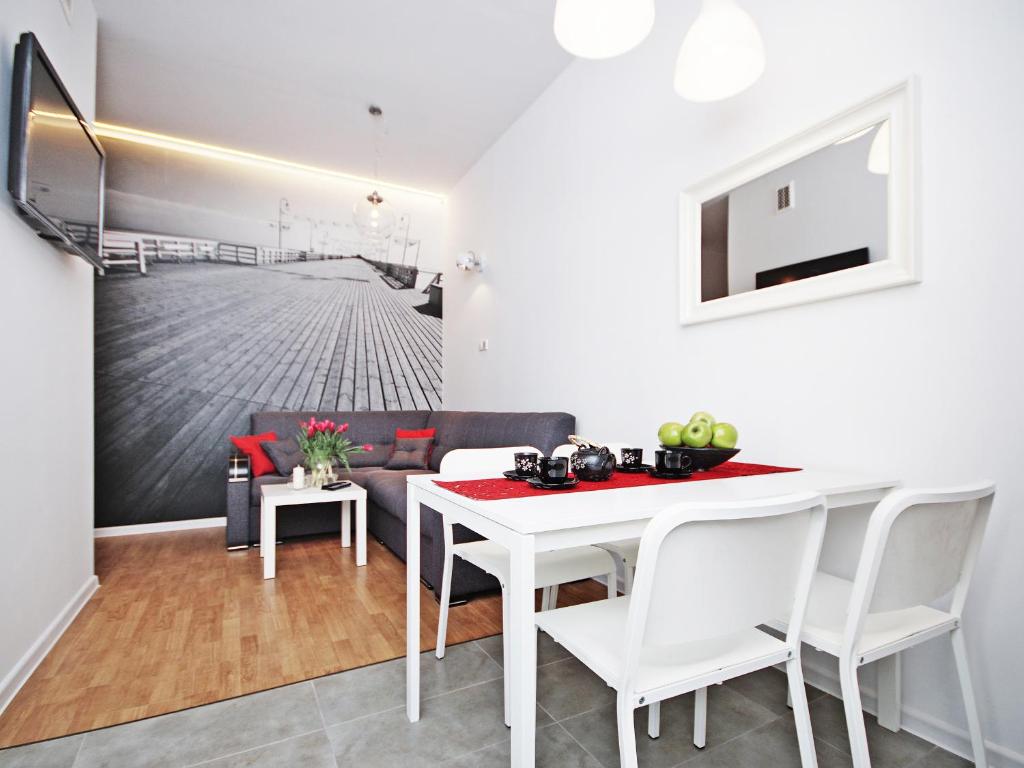 ソポトにあるSopot Comfy Apartment SAのダイニングルーム(白いテーブル、椅子付)