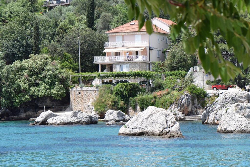 una casa junto a un río con rocas en Villa Ana Apartments en Molunat