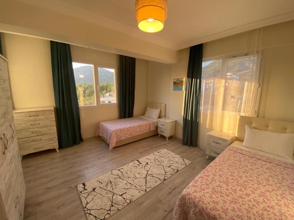 a hotel room with two beds and a window at Azize in Fethiye