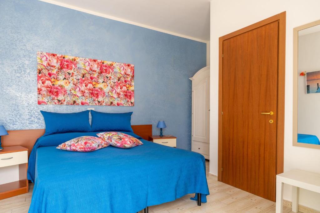 a bedroom with a blue bed with two pillows on it at Villa Elisa in Torre Lapillo