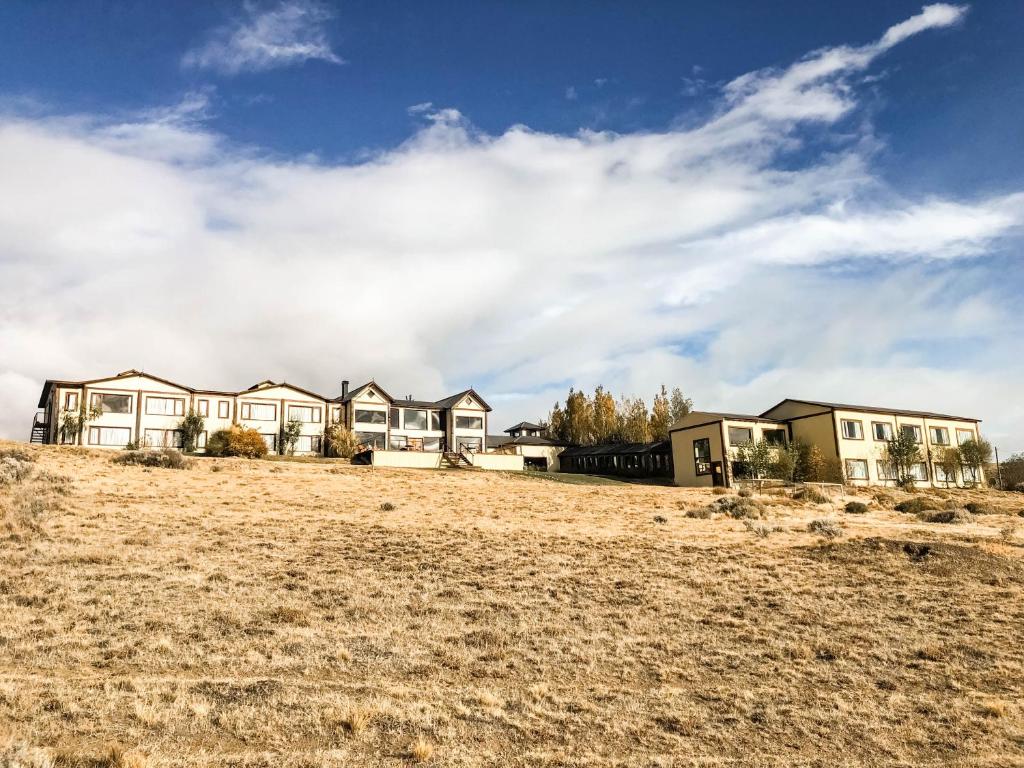 a row of houses on top of a field at Hosteria La Estepa in El Calafate