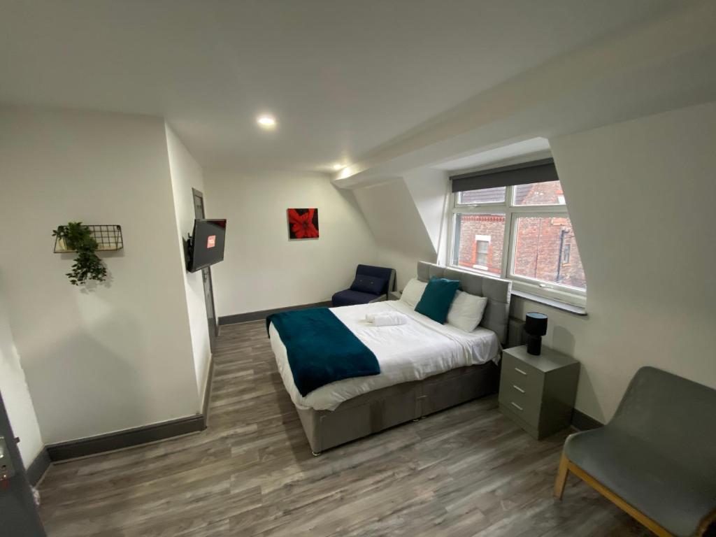 a bedroom with a bed and a chair and a window at Nice Ensuite Rooms close to Anfield Stadium & city centre in Liverpool