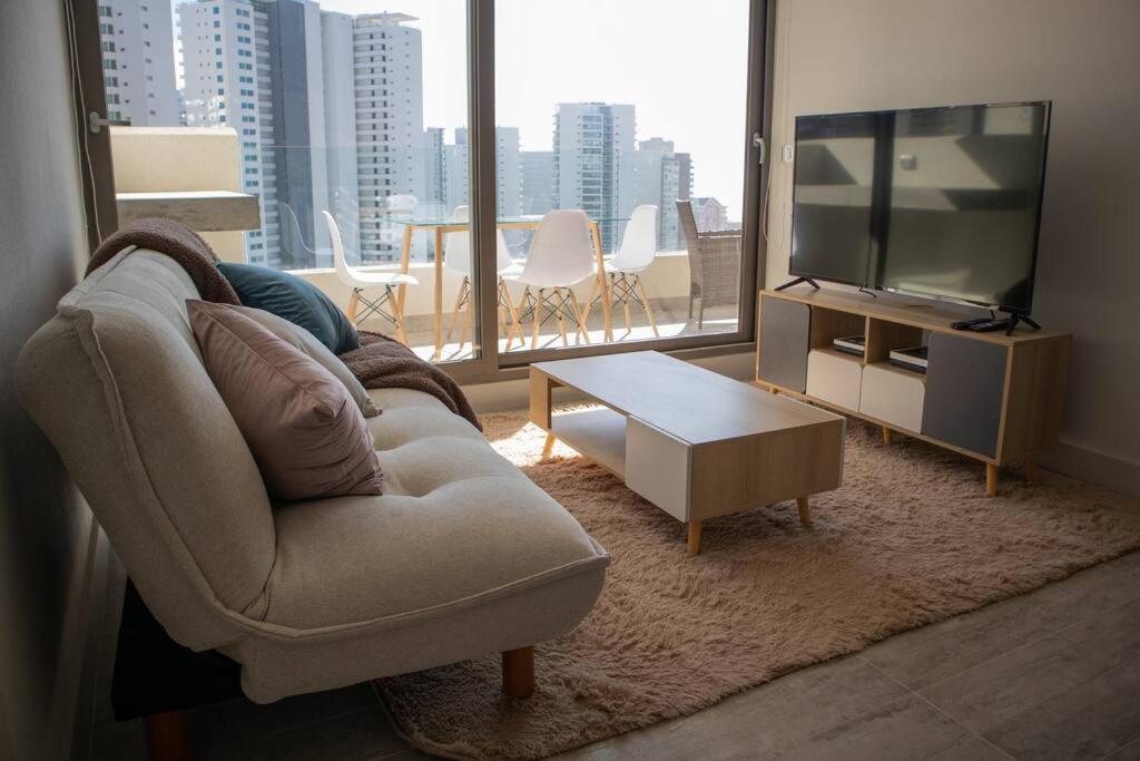 uma sala de estar com um sofá e uma televisão em Hermoso departamento amoblado en Concón 2D/2B/1E em Concón