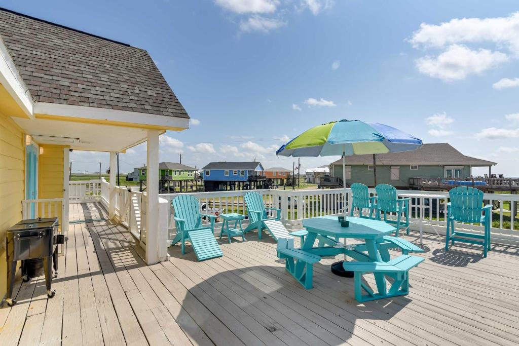 eine Terrasse mit einem Tisch, Stühlen und einem Sonnenschirm in der Unterkunft Home with Ocean-View Deck and BBQ Steps to the Beach! in Surfside Beach