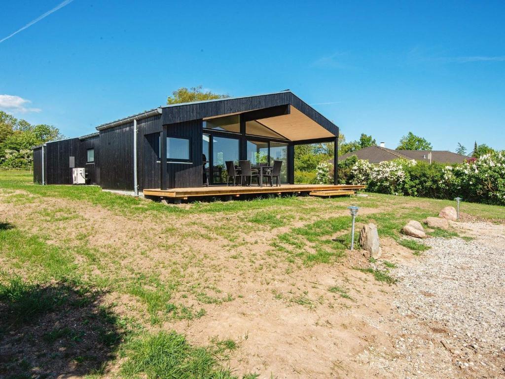 una casa negra sentada en la cima de un campo en Holiday home Rønde IX, en Rønde