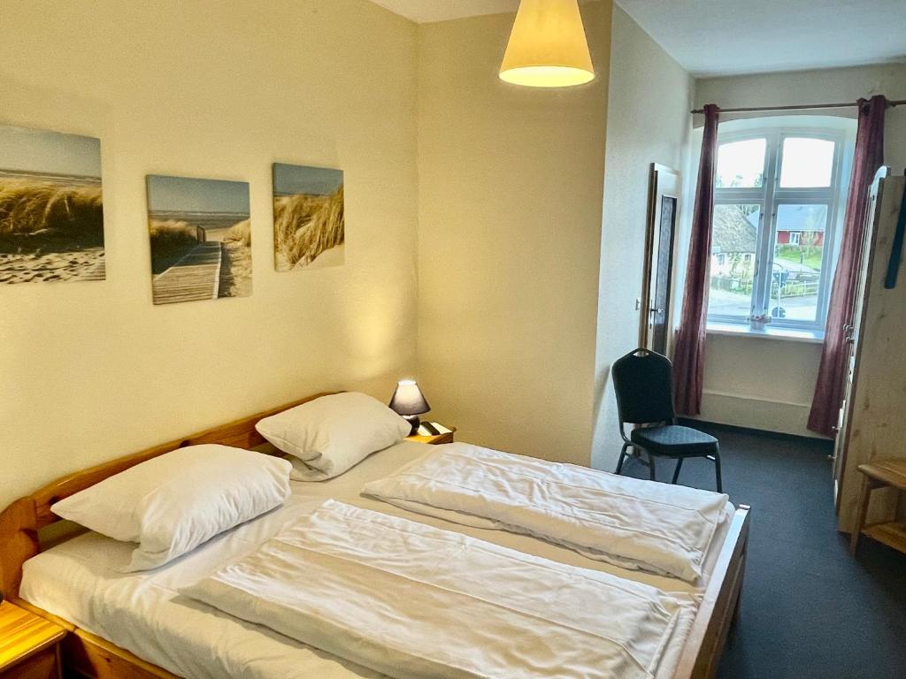 a bedroom with two beds and a window at Niemeyers Landgasthof und Pension in Süderstapel