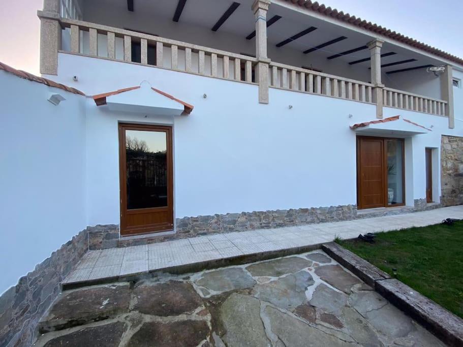 a white house with a balcony and a walkway at Villa BB in Sanxenxo