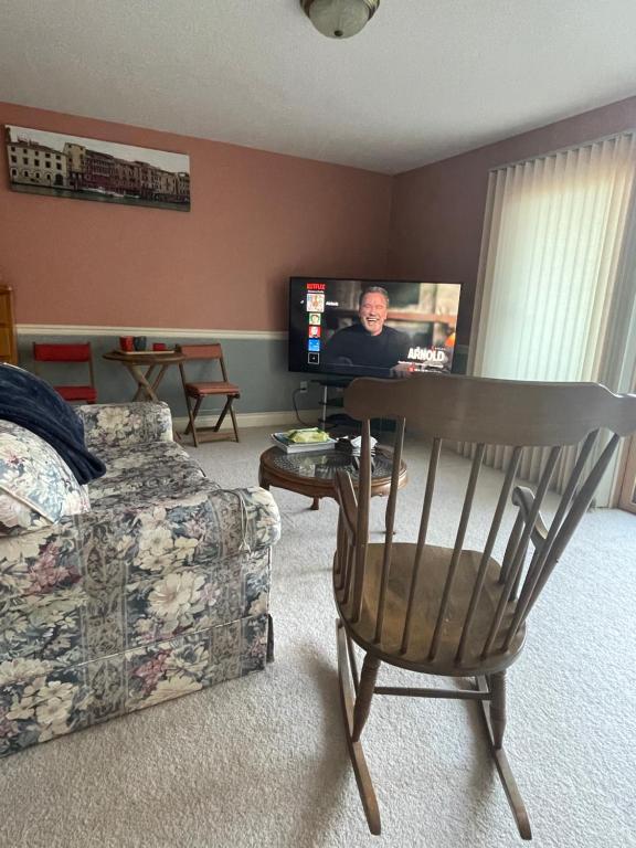 a living room with a chair and a flat screen tv at Panoramic Ocean View in Nanaimo