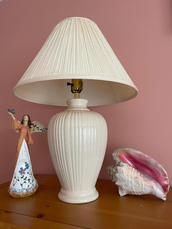 a white lamp sitting on top of a table with a doll at Panoramic Ocean View in Nanaimo