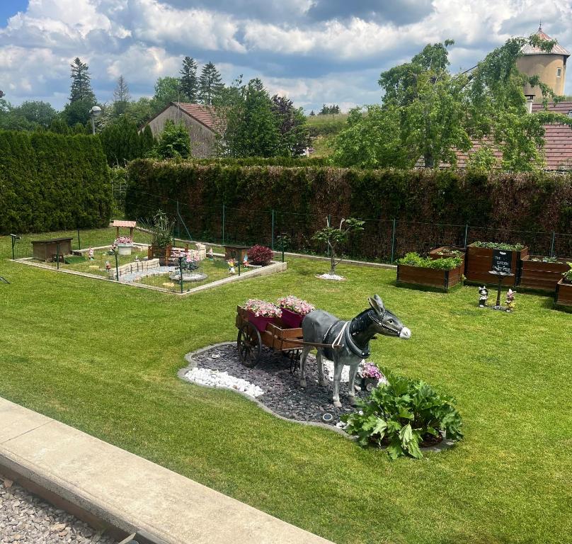 una estatua de un caballo tirando de un carro en un jardín en haut-Jur'Accueillant en Saint-Laurent-en-Grandvaux
