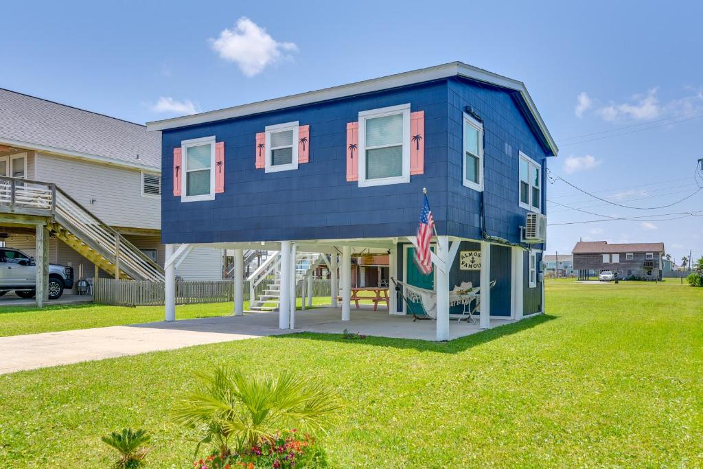 una casa azul con una bandera en el patio en Bright Jamaica Beach Getaway Less Than 1 Mi to Shore!, en Galveston