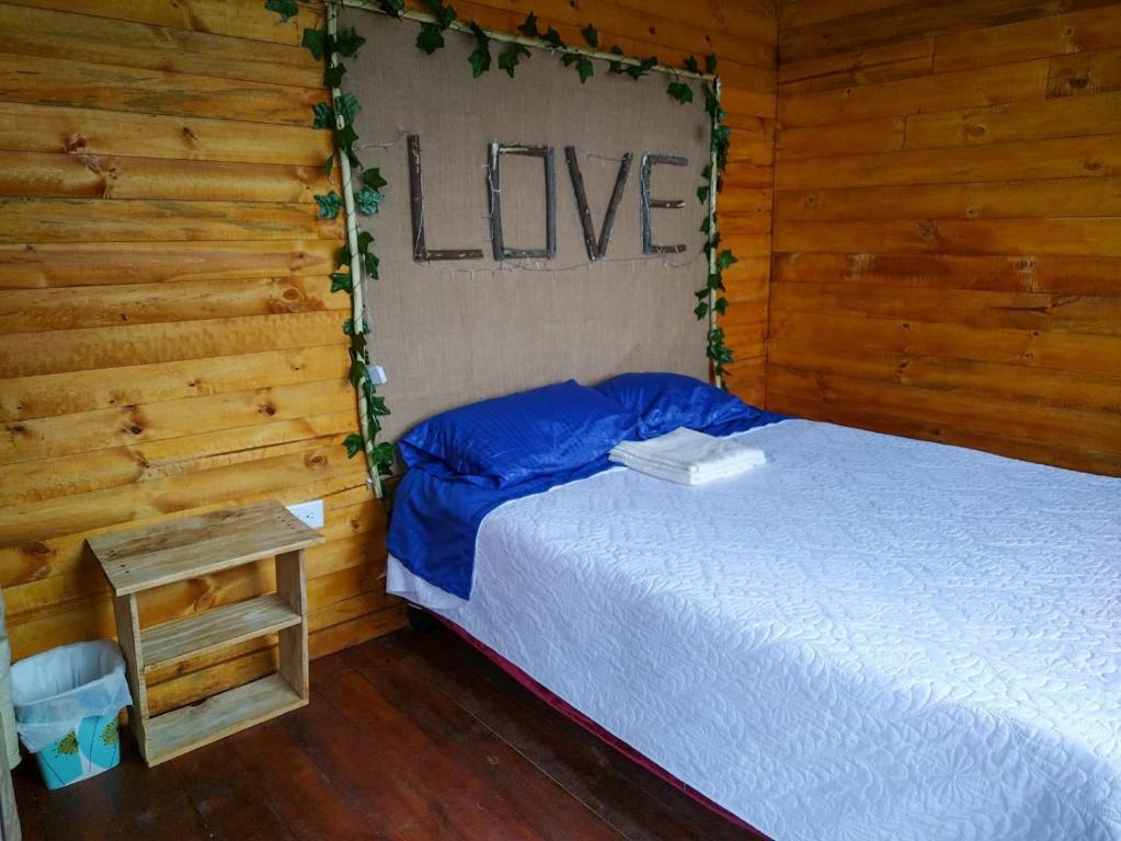 a bedroom with a bed and a sign that says live at Glamping entre bosques in La Calera