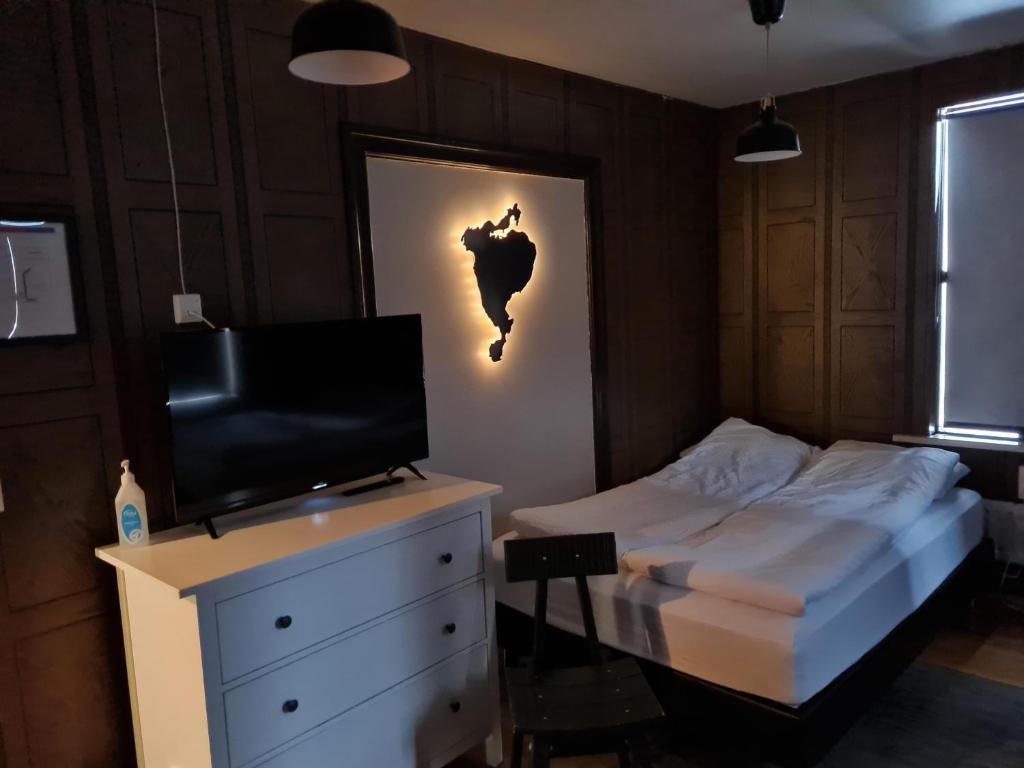 um quarto com uma cama e uma televisão numa cómoda em Lava Guesthouse em Vestmannaeyjar