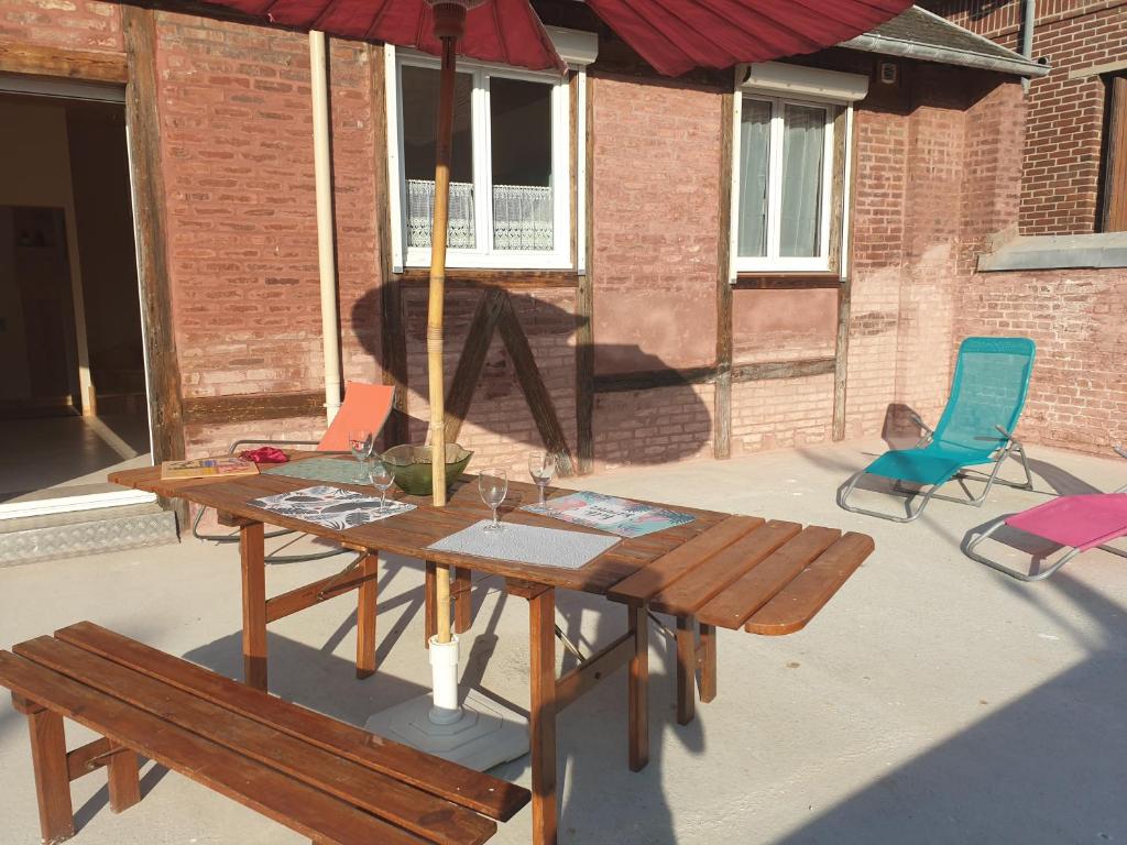 stół piknikowy z 2 krzesłami i parasolem w obiekcie Notre nid - Grande terrasse privée en bord de mer, au coeur du quartier historique du Tréport ! w mieście Le Tréport