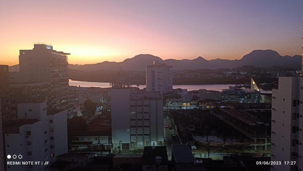 a view of a city at sunset with buildings at Flat no coração de Guarapari,150 metros da praia com vista encantadora in Guarapari