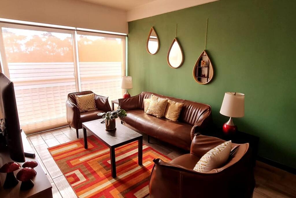 a living room with a leather couch and a table at Torre Pamplona 409 -Nuevo y Cómodo- Apartamento in Guatemala