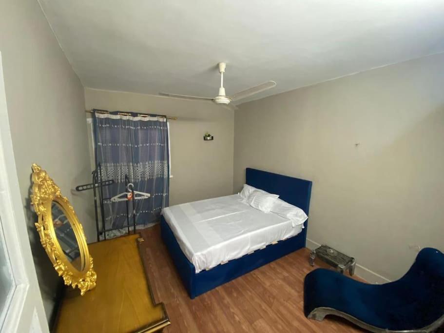 ein Schlafzimmer mit einem Bett, einem Spiegel und einem Stuhl in der Unterkunft Cozy 3-BR Apartment for families only in Agouza! in Kairo