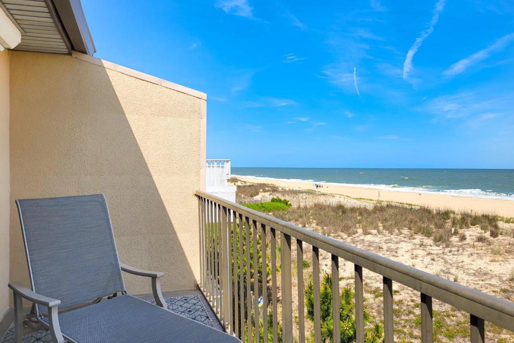 a blue chair sitting on a balcony overlooking the beach at Karoll I Unit D in Ocean City