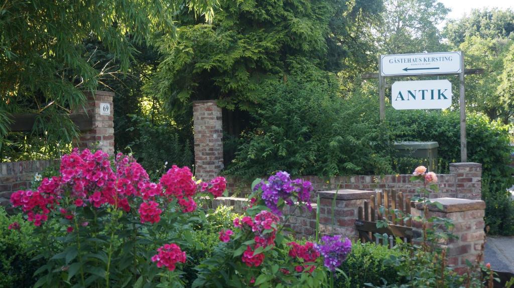 a garden with flowers and a sign that reads autism at Gästehaus Kersting in Meerbusch