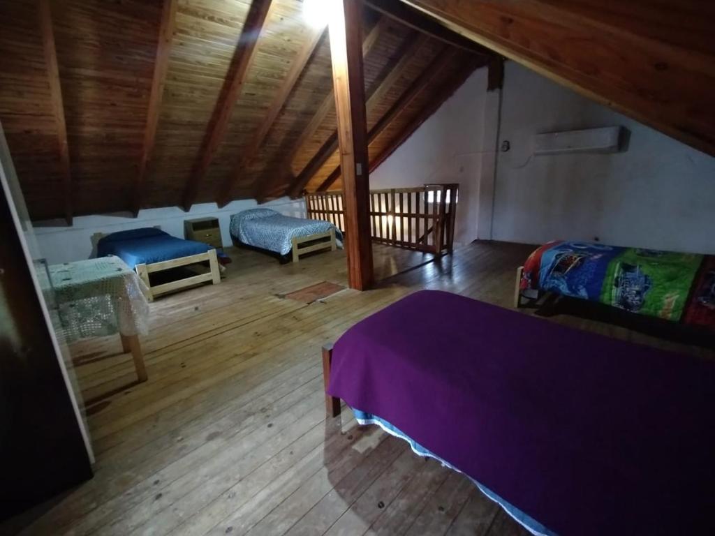 a attic room with two beds and a wooden floor at AMALUR in Sañogasta