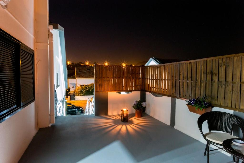 a balcony with a table and chairs at night at Casa do Calço in Ponta Delgada