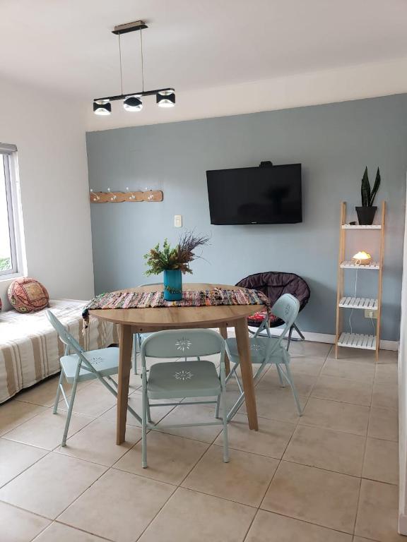 a living room with a wooden table and chairs at Departamento Jardín Malbec!! in Ciudad Lujan de Cuyo