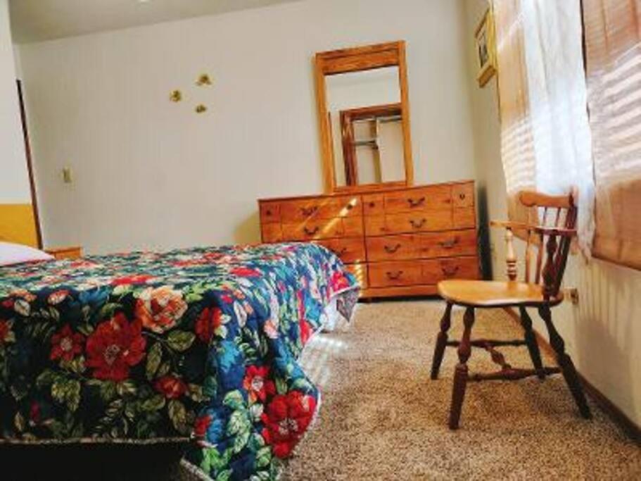 um quarto com uma cama, uma cadeira e uma cómoda em Golden Sunflower's Apartment B em Lawton