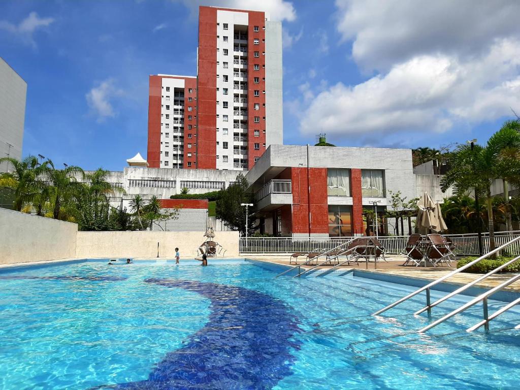 a large swimming pool in front of a tall building at Apartamento completo in Manaus