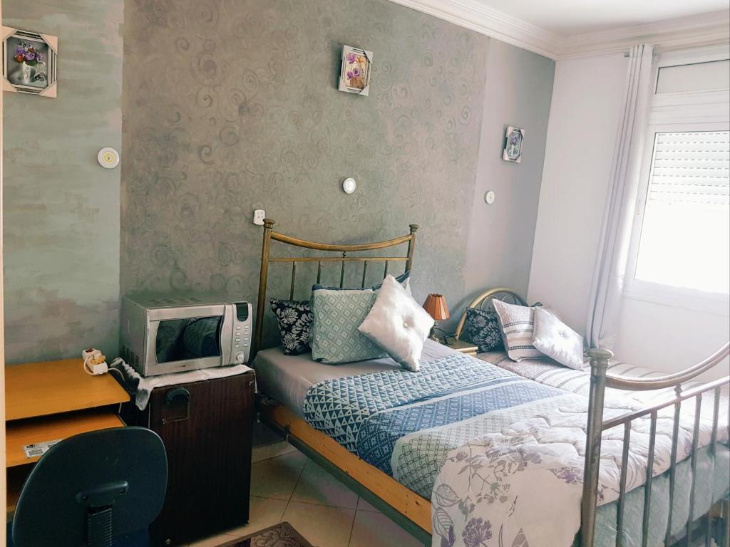 um pequeno quarto com uma cama e uma televisão em ÆrtisticŠpace In The Center Room em Tânger